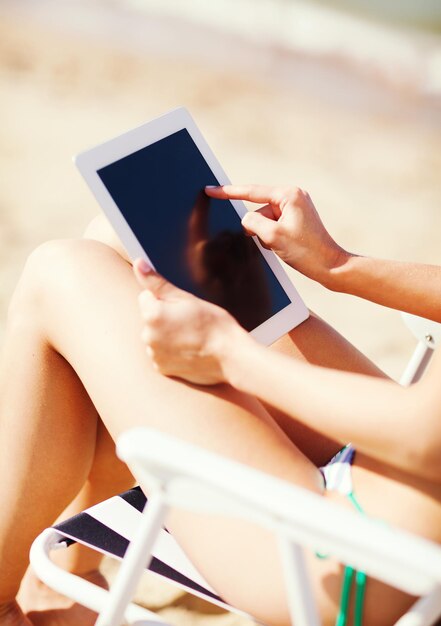 sommerferien, urlaub, technik und internet - mädchen, das tablet-pc auf dem strandkorb betrachtet