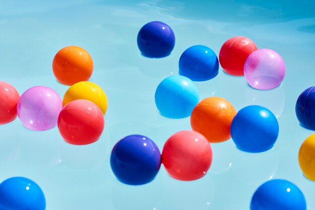 Sommerferienkonzept mit buntem Ball im Schwimmbadwasser, Nahaufnahme