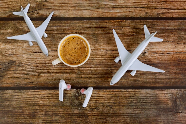 Sommerferienreisekonzeptplanung Modellflugzeugflugzeug und Kopfhörer in Kaffeetasse