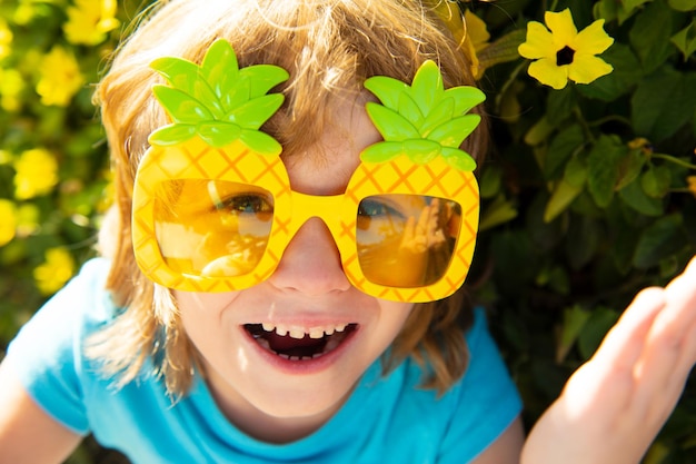 Sommerfestkinderzeit-Kindheitskonzeptjunge in der verrückten Sonnenbrille