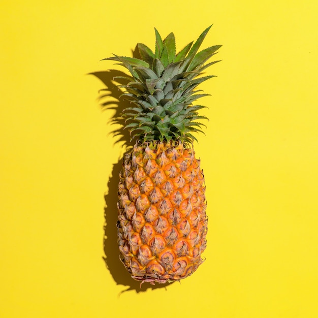 Sommerfrucht. Ananas auf leuchtend gelbem Hintergrund.