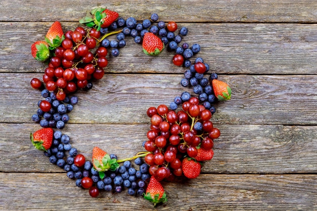 Sommerfrüchte auf einem Holztisch. Heidelbeeren Trauben Erdbeeren