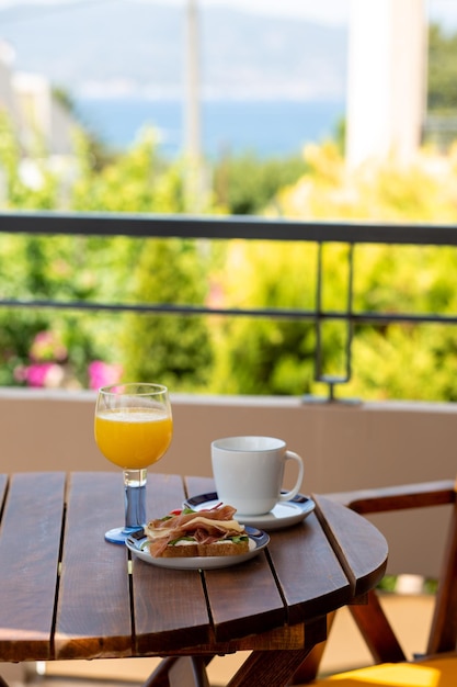 Sommerfrühstück draußen am Meer Sommerurlaub im Hotel Sandwich mit Kaffee und Orang