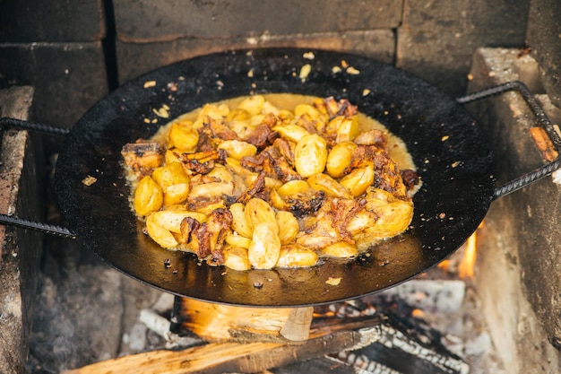 Sommergericht Fleisch mit Gemüse, Zwiebeln und Kartoffeln, das im Kessel gebraten wird Blick von oben Kaukasische oder asiatische Küche