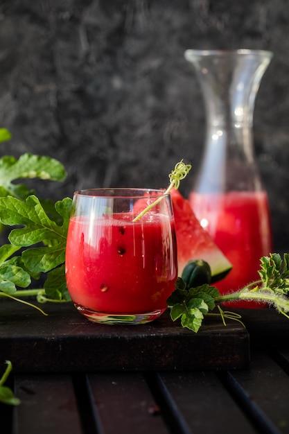 Sommergetränk Kalter Wassermelonensaft mit Limette und Minze auf einem Holzbrett Beerenfrucht-Smoothie