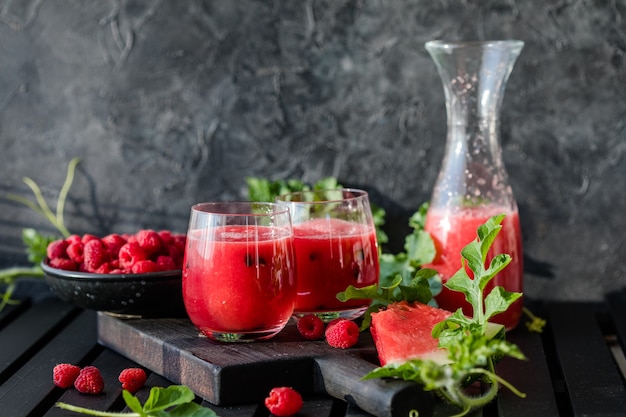 Sommergetränk Kalter Wassermelonensaft mit Limette und Minze auf einem Holzbrett