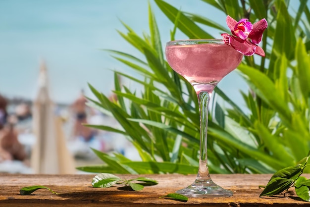 Sommergetränke Rosafarbener alkoholischer Daiquiri-Cocktail mit geschmückter Blume an der Strandbar Sea Resort