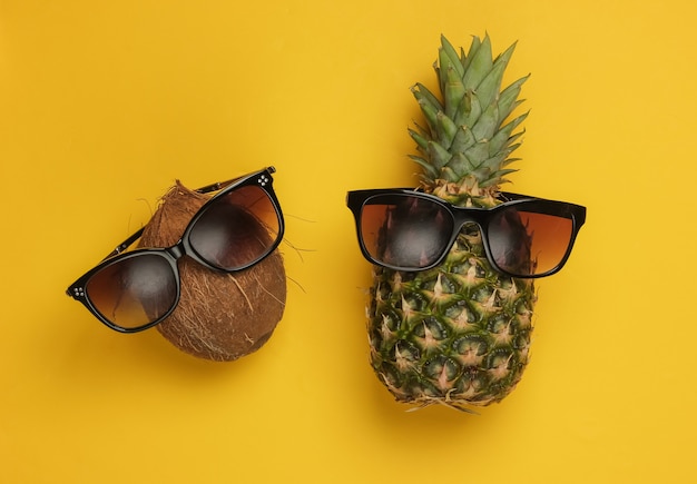 Sommerhintergrund. Spaß und Humor Konzept. Ananas und Kokosnuss mit Sonnenbrille