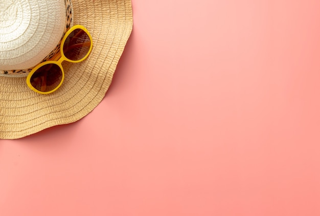 Sommerhintergrund von Seestern, Strohhut, Sonnenbrille auf rosa Hintergrund
