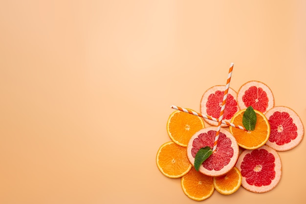 Sommerhintergrundkonzept geschnittene Orange, Grapefruit, Zitrone, Limette, Minze auf orangem Hintergrund