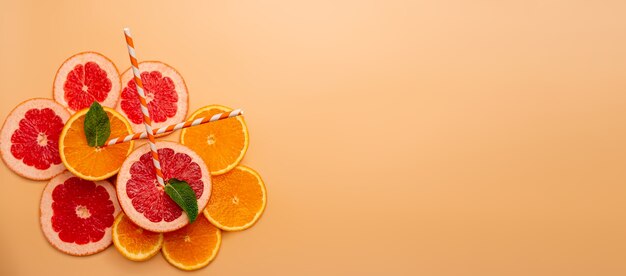 Sommerhintergrundkonzept in Scheiben geschnittene Orange, Grapefruit, Zitrone, Limette, Minze auf orangefarbenem Hintergrund