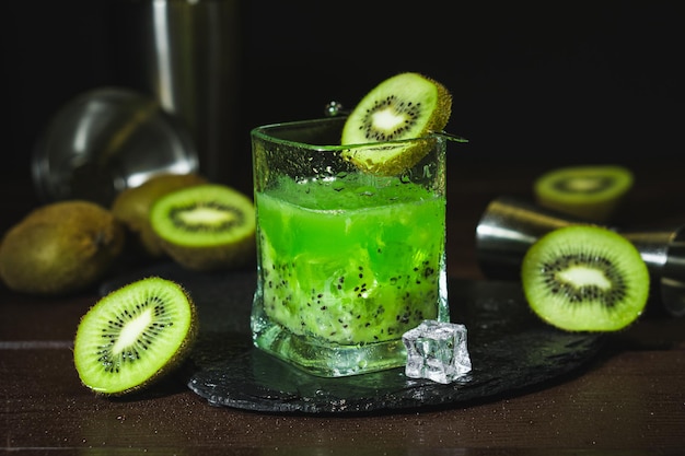 Sommerkaltes Getränk und Getränke Alkoholcocktail mit Kiwi und Eis im Whiskeyglas auf schwarzem Tisch