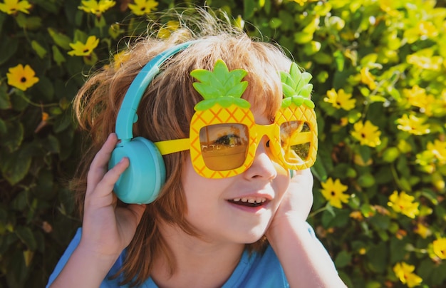 Sommerkind Kind, das Musik hört Kind mit verrückter Sonnenbrille glücklicher Junge mit Partybrille