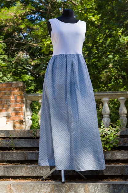 Sommerkleid aus Jersey Weißblaues Kleid auf Schaufensterpuppe Weiblicher Sarafan aus natürlichem Stoff Natürlicher Hintergrund