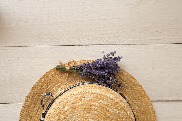 Sommerkomposition Draufsicht auf Strohhut ist ein kleines duftendes Bouquet. Draufsicht