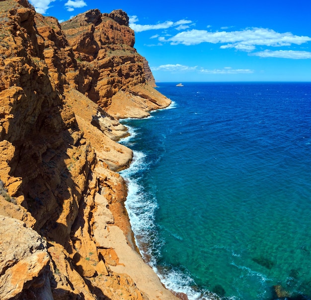 Sommerküstenlandschaft des Mittelmeers mit roter Erde in der Nähe der Stadt Benidorm (Costa Blanca, Alicante, Spanien). Stichbild mit zwei Schüssen.