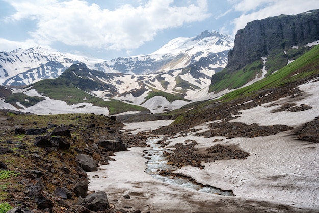 Sommerlandschaft mit Fluss- und Gebirgsschnee.