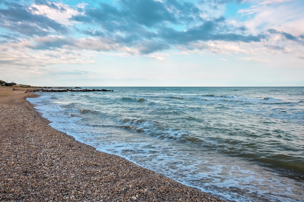 Sommerlandschaft mit Meer, Wellen, bewölkten Wolken.