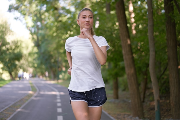 Sommerlaufpark der Frau, die Asphaltstraße läuft