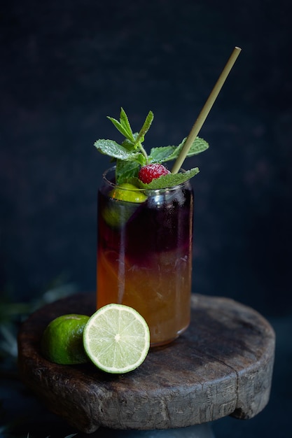 Foto sommerlich leckeres erfrischungsgetränk mit rose und sommerfrüchten, serviert im glas auf dunklem hintergrund