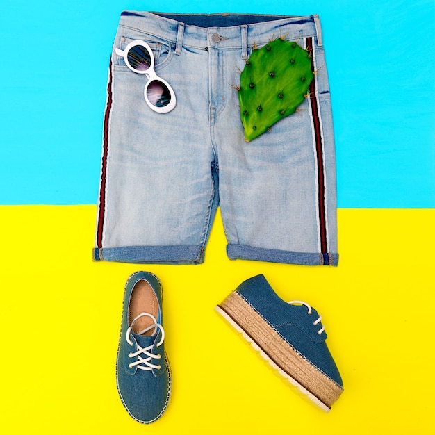 Sommerlicher Strandlook. Jeansshorts, Sonnenbrillen, stilvolle Jeansschuhe auf der Plattform. Modekonzept