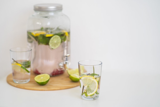 Sommerliches Kühlgetränk mit Beeren und Zitruslimonade in einer wiederverwendbaren Glasflasche und Gläsern hausgemacht...