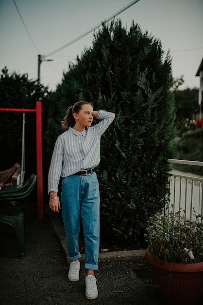 Sommerliches sonniges Lifestyle-Modeporträt eines jungen stilvollen Mädchens, das auf der Straße spazieren geht und süßes, trendiges Outfit trägt, heiße Lattes trinkt und lächelnd die Wochenenden in der Kaffee-Restlounge genießt