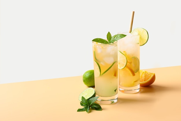 Sommerlimonade oder Cocktail mit Orangen- und Limettenscheibe auf Farbhintergrund erfrischendes Getränk