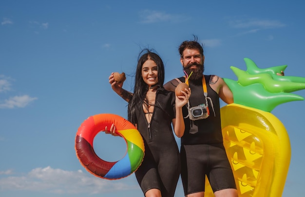 Sommerpaarurlaub am Strand. Reizvolle Frau im Bikini. Sommerkonzept. Sexy Mann im Badeanzug. Surfbrett.