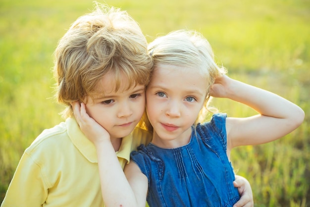 Sommerporträt des glücklichen netten Kindes Glückliches Kind auf Sommerfeld Schöne Kinder Erste Liebe Kind spielt Glückliche Kindheit Das Konzept der Kinderfreundschaft und Freundlichkeit Süße Engelkinder