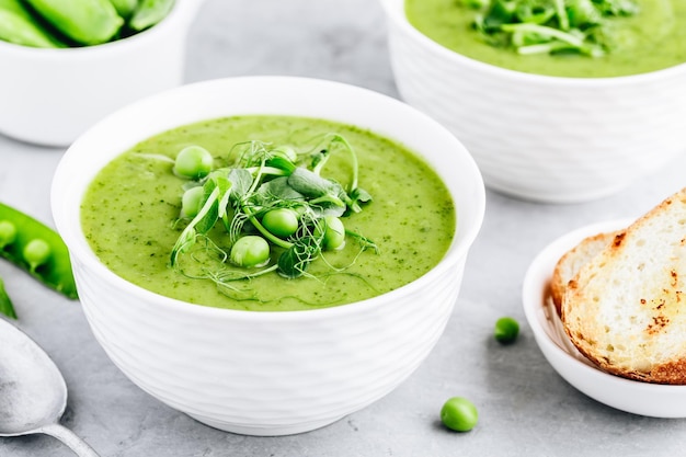 Sommersahnesuppe mit grünen frischen Erbsen schießt Nahaufnahme