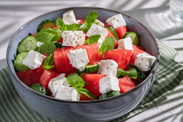 Foto sommersalat mit wassermelone, minze, gurke und feta-käse nahaufnahme schatten