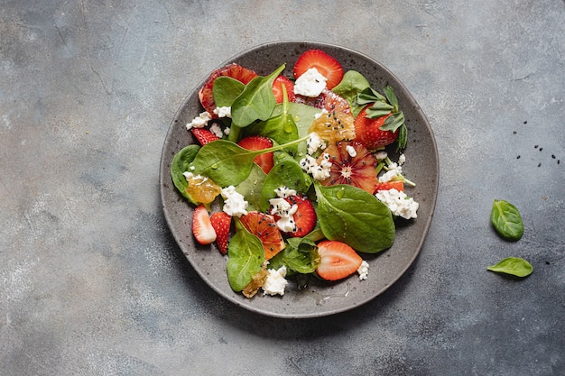 Sommersalatschüssel mit Spinat, Erdbeere, Hüttenkäse, Blutorangen und Honig.