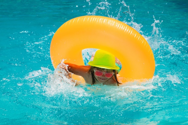 Sommerspaß Kinder Gesicht Kind plantschen und schwimmen auf aufblasbaren Spielzeugring im Pool schwimmen Wassersport ac