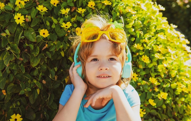 Sommerstimmung glückliches Kind in verrückter Brille und Kopfhörer glücklicher Junge in Party-Sonnenbrille sorgloses Kind