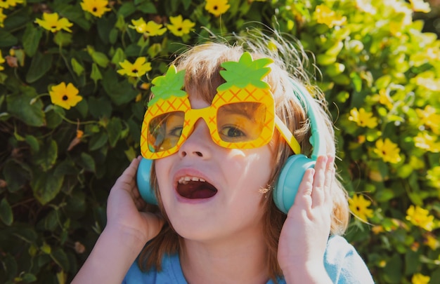 Sommerstimmung Kind hört Musik Kind mit verrückter Sonnenbrille Fröhlicher Junge mit Partybrille