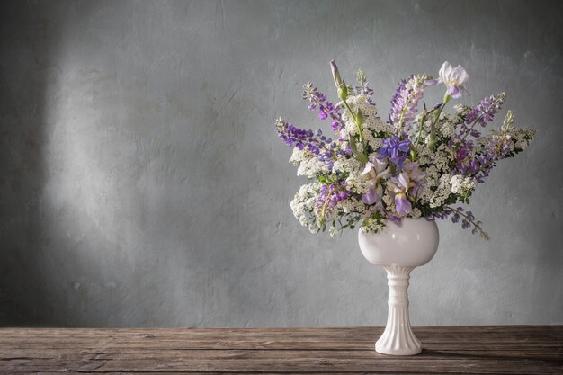 Sommerstrauß in der weißen Vase auf grauem Hintergrund