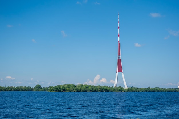 Sommertag-Aussicht über den Fluss Daugava auf den Riga-Fernsehturm unter klarem blauen Himmel