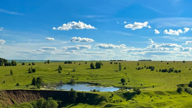 Sommertag blauer See auf grünen Ebenen und Hügeln