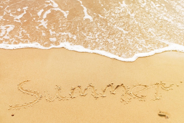 Sommertext geschrieben am Sandstrand und Meereswellen Entspannen auf der tropischen Insel Sommerurlaubskonzept Hallo Sommerkonzept