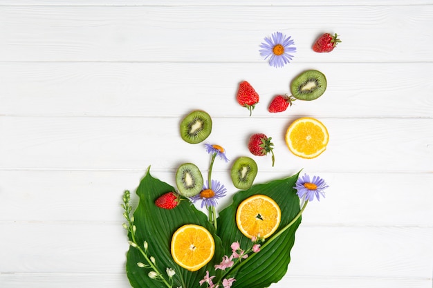 Sommerthema, Früchte und Blumen auf einer weißen Tafel