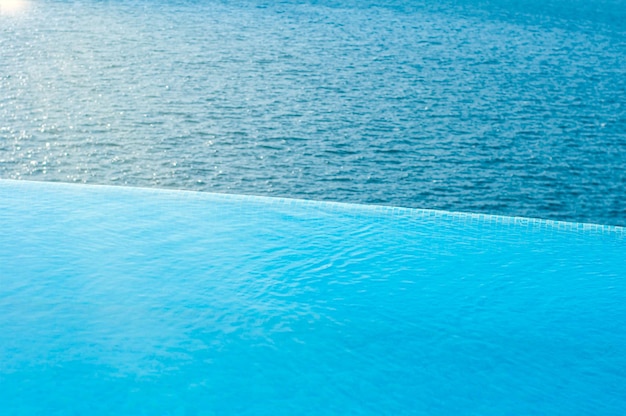 Sommerurlaub am Pool. Infinity-Pool mit Meer an hellen Sommertagen