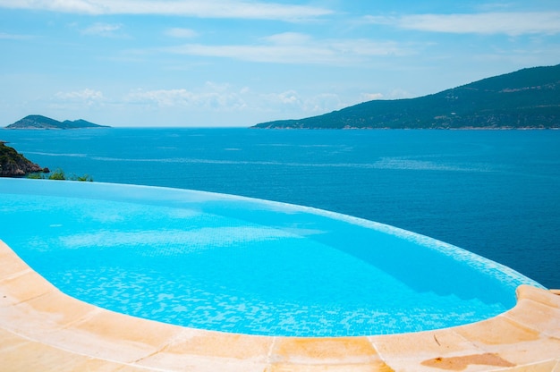 Sommerurlaub am Pool. Infinity-Pool mit Meer an hellen Sommertagen