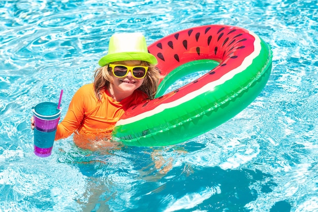 Foto sommerurlaub spaß süßes kind im schwimmbad kind spielt im blauen wasser mit schwimmring