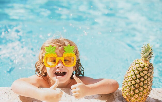 Sommerurlaubsspaß Nettes Kind im Schwimmbad Sommer-Ananas-Frucht Lustiges erstauntes Gesicht