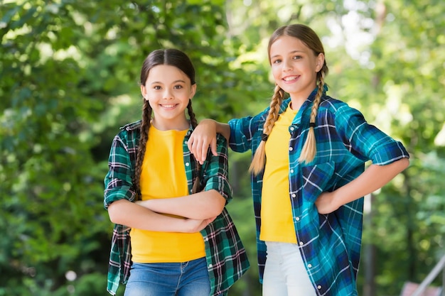 Somos uma criança moda casual felicidade infância feliz dia das crianças passar tempo e se divertir juntos melhores amigos da escola conceito de amizade pequenas meninas felizes usam camisa quadriculada