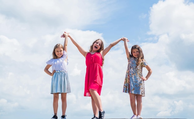 Somos uma linda garota adolescente de mãos dadas, estilo de moda infantil, amizade feminina e irmandade, infância feliz, crianças fofas no fundo do céu, beleza, verão, aparência elegante