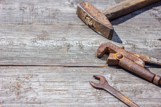 son las herramientas sobre fondo de madera alicates martillo y llave