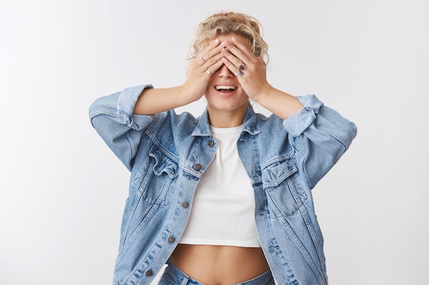 Foto sonhadora despreocupada atraente jovem loira europeia apto instrutor de ioga feminino receber surpresa presente fechar olhos palmas sorrindo antecipando presente bolo de aniversário, curioso parede branca de pé