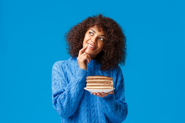 Sonhadora e boba pensativa namorada afro-americana preparada bolo como presente